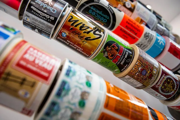 Custom label printing with assorted product label rolls in different designs and colours.